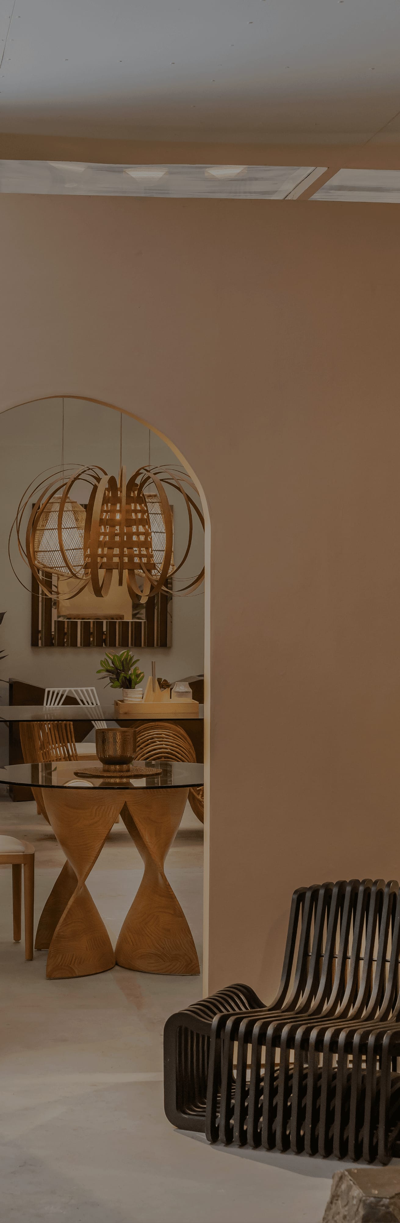 Vito Selma showroom interior with an arched doorway, sculptural pendant lighting, and woven furniture