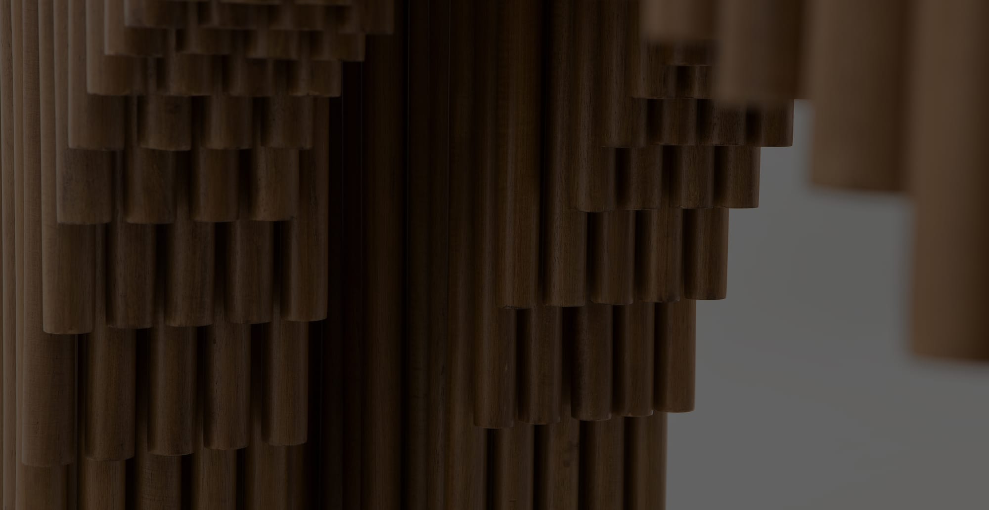 Close view of a stepped screen built from densely packed dark wooden dowels