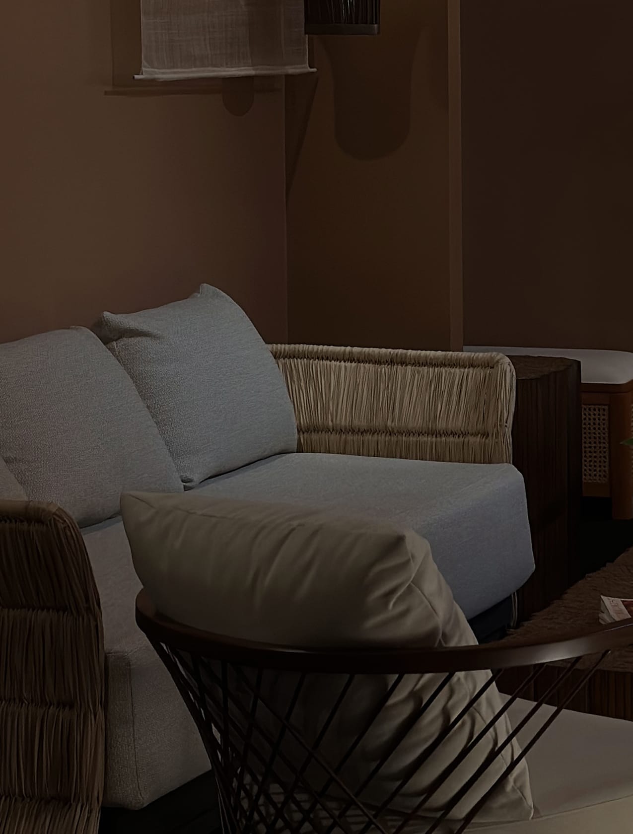 Makati showroom seating vignette with a pale blue sofa, fringed woven armchairs, and an orchid on a stone-topped table